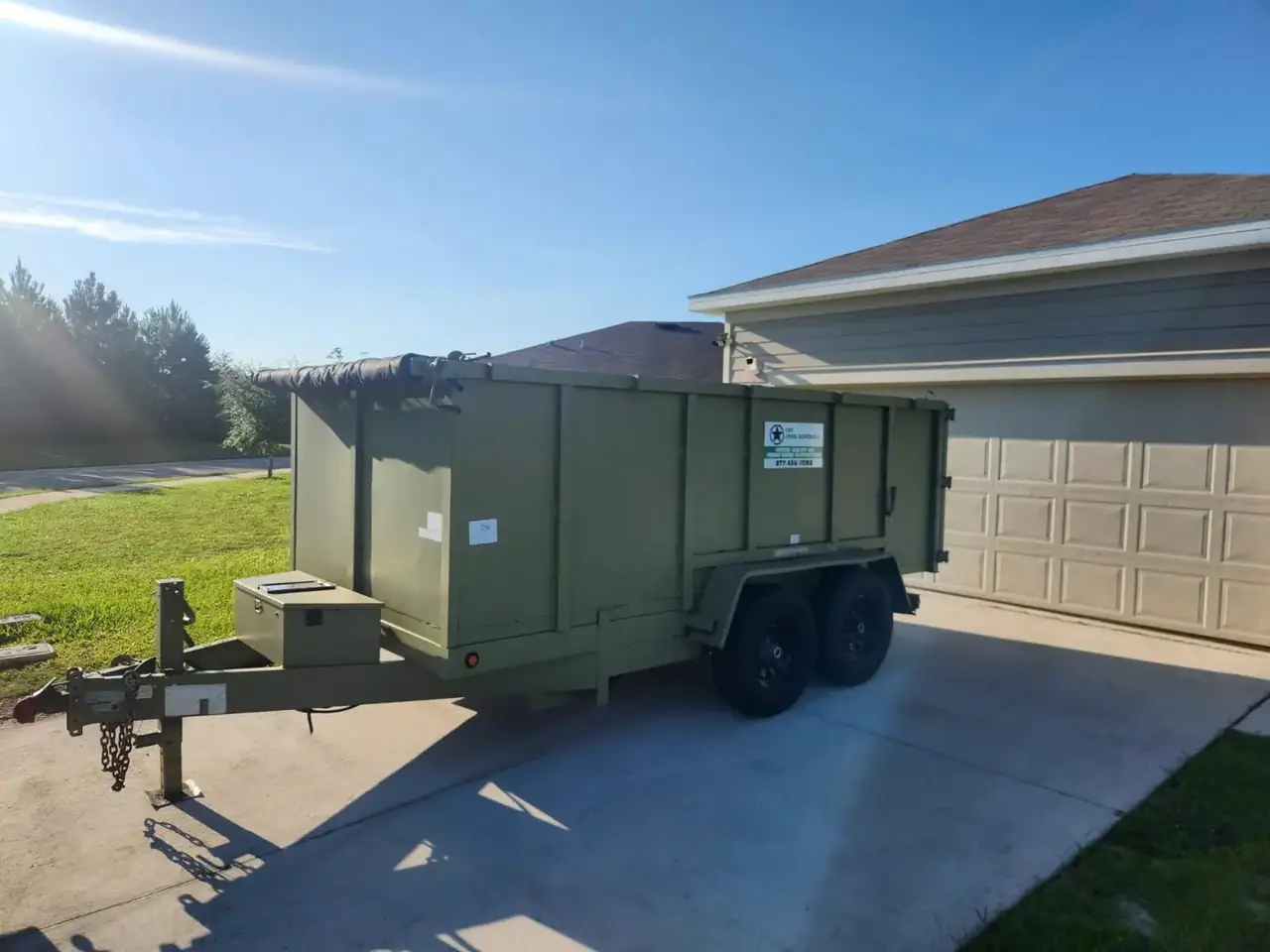 The Junk Generals dump trailer positioned in a residential driveway