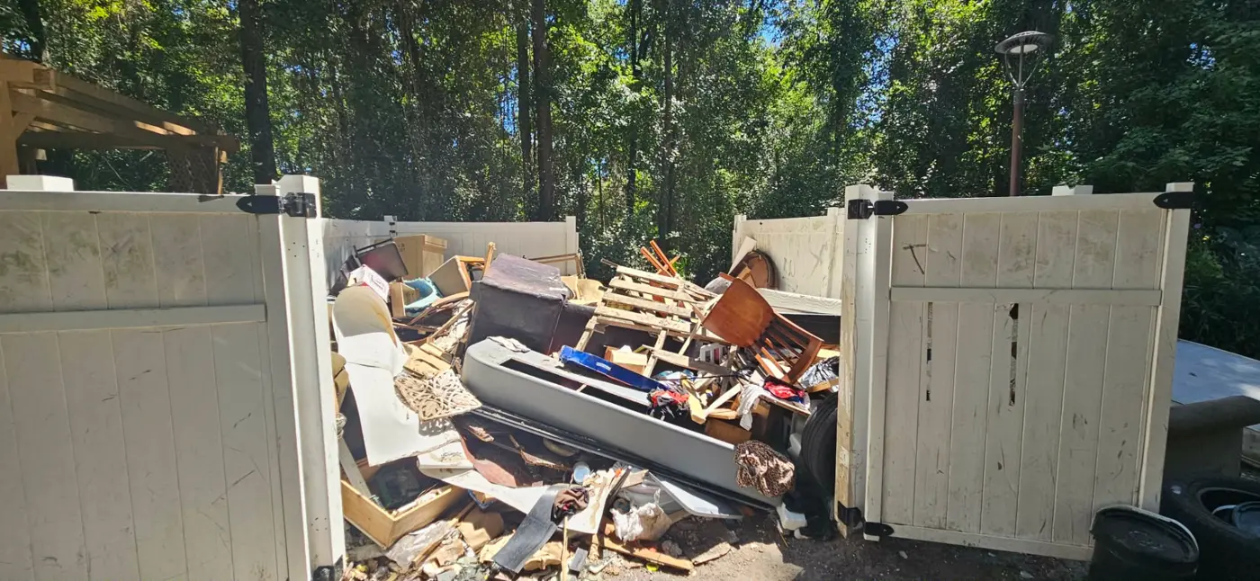 Commercial property collection enclosure filled with furniture and debris before removal