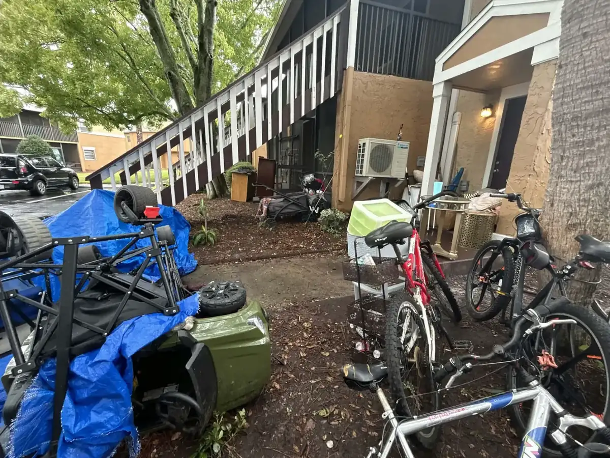 Apartment walkway filled with bicycles, furniture, and belongings before an eviction set-out removal