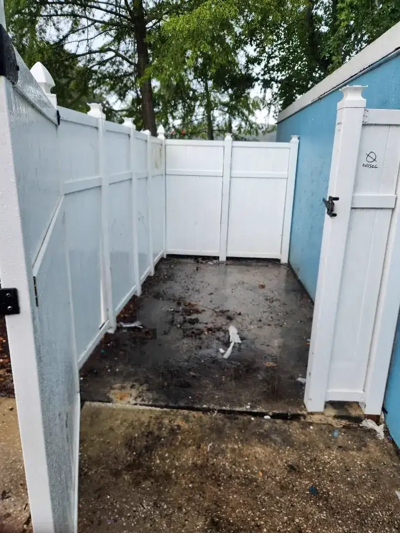 Fenced commercial bulk trash area fully cleared after removal